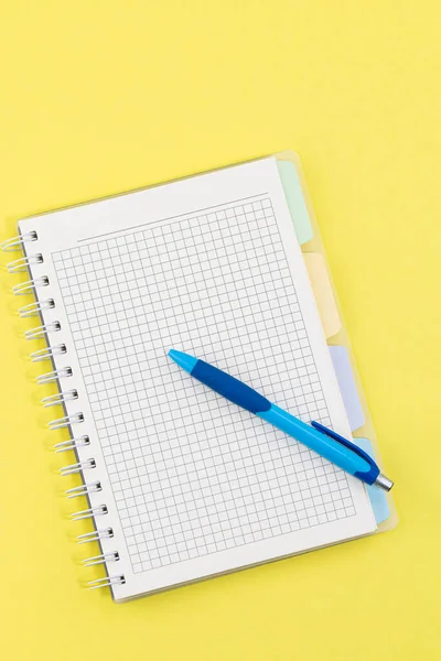 空白のノートブックとペンが黄色の背景に — ストック写真