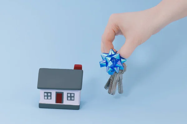 Mano Sostiene Las Llaves Una Casa Sobre Fondo Azul Con — Foto de Stock