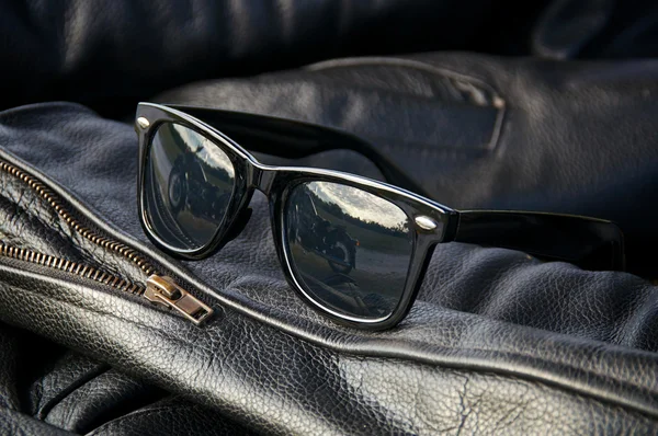 Leather jacket detail with sunglasses — Stock Photo, Image