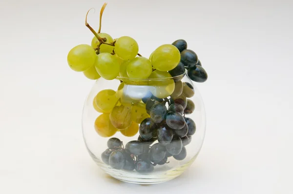 Red and green grapes in glass vase — Stock Photo, Image