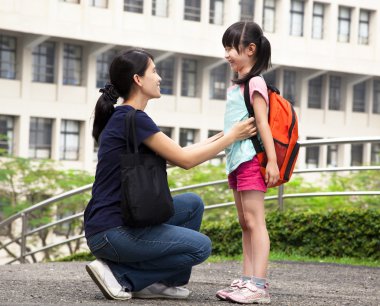 Back to school.happy asian mother with daughter in school clipart