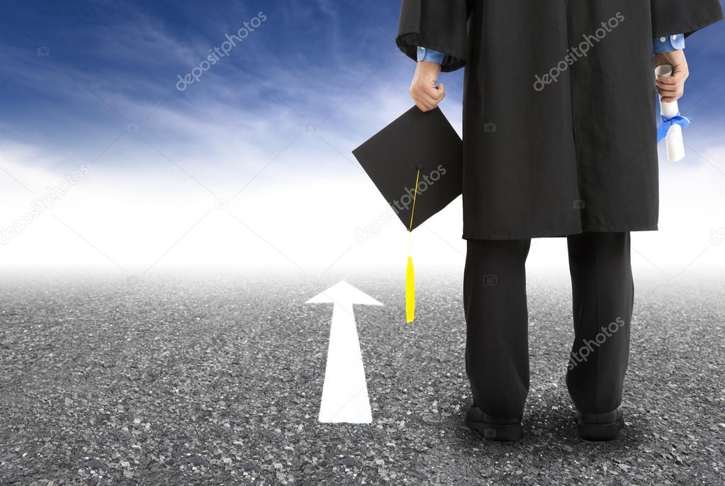 Graduate standing on the road and forward arrow