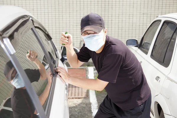 Άνθρωπος στη μάσκα που προσπαθεί να κλέψει ένα αυτοκίνητο — Φωτογραφία Αρχείου