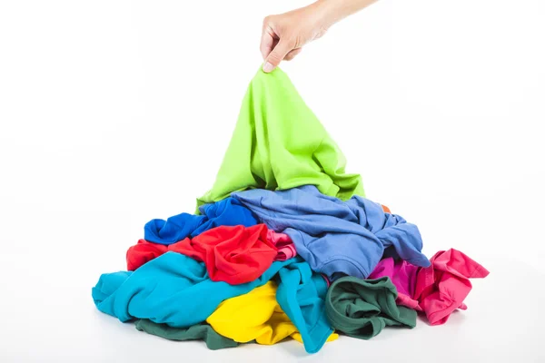 Hand pick-up een shirt in stapel van kleurrijke kleding — Stockfoto