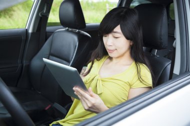genç kadın arabada Tablet PC'yi kullanma