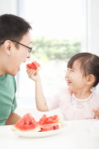 Happy little girl with father eating fruits — Stock Photo, Image