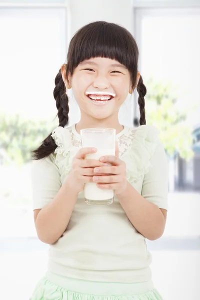 Menina feliz segurando um copo de leite fresco — Fotografia de Stock