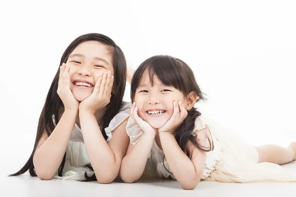 Glada två asiatiska tjejer på den vita bakgrunden Royaltyfria Stockfoton