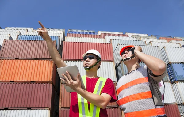 Dva pracovníci s tablet pc a stojí před hromadou kontejner — Stock fotografie