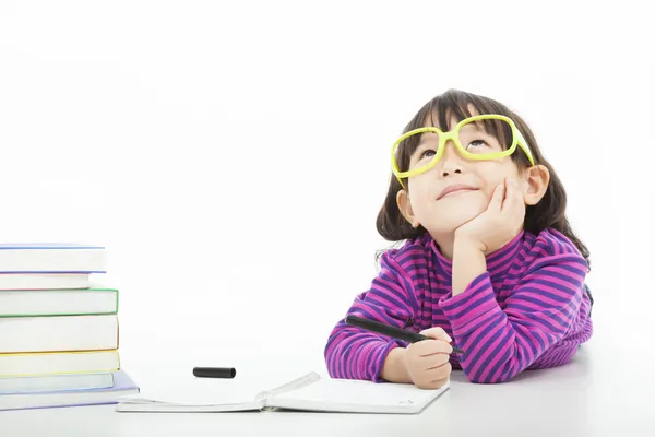 Petite fille pensant ou rêvant pendant la préparation des devoirs — Photo