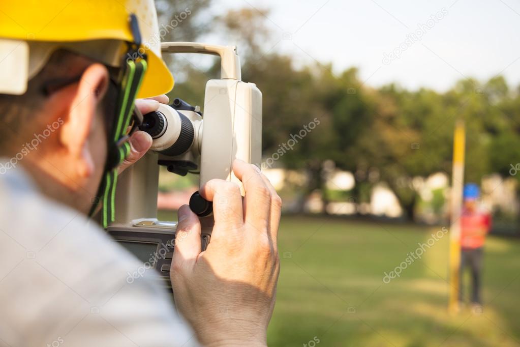 Surveyor engineer with partner making measure on the field