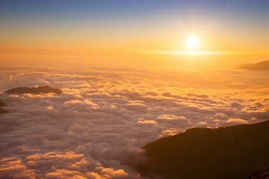 Mountain sea of clouds in sunset light clipart