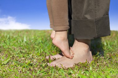 Family feet on the grass with cloud background clipart