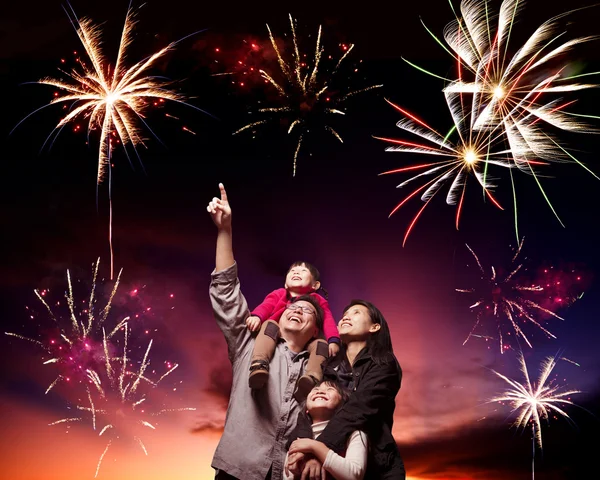 Happy family looking fireworks in the evening sky — Stock Photo, Image