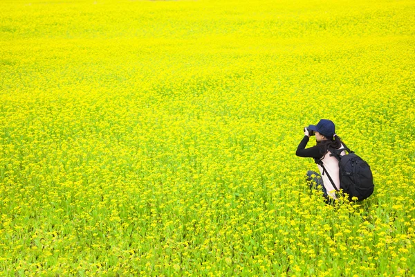 Молодая женщина фотограф делает фотографии цветов — стоковое фото