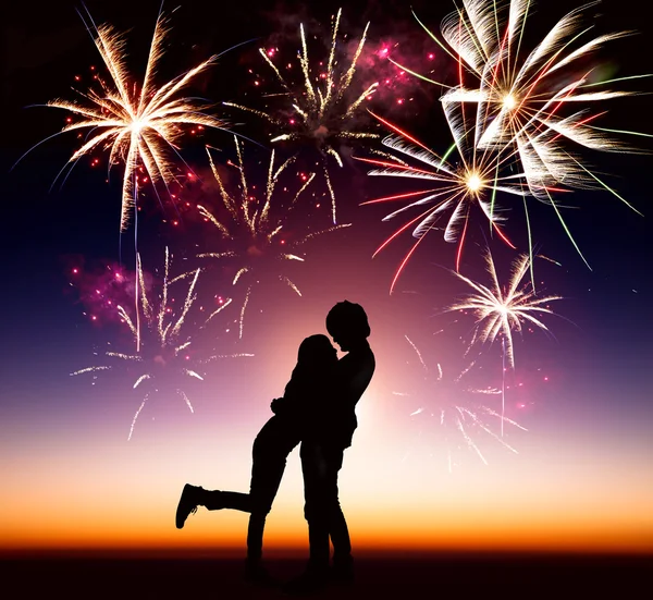 Feliz pareja joven con fondo de fuegos artificiales —  Fotos de Stock