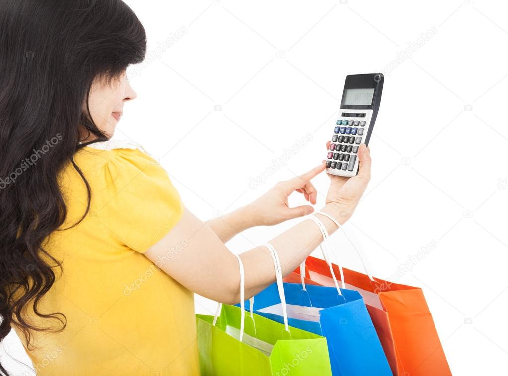young woman holding shopping bags and calculator