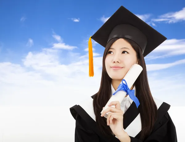 Usměvavý absolvent žena drží titul s pozadím mrak — Stock fotografie