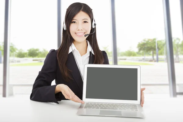 Uśmiechnięta kobieta z zestawem słuchawkowym i laptopa w biurze — Zdjęcie stockowe