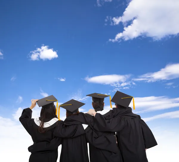 Cuatro estudiantes de posgrado mirando al cielo — Foto de Stock