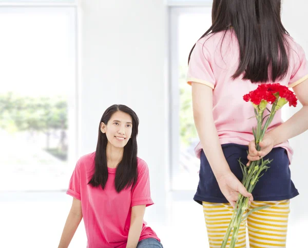 母の日にお母さんにカーネーションの花を与える少女 — ストック写真