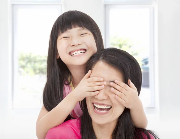 Gelukkig meisje dekking van haar moeder ogen voor de lol — Stockfoto