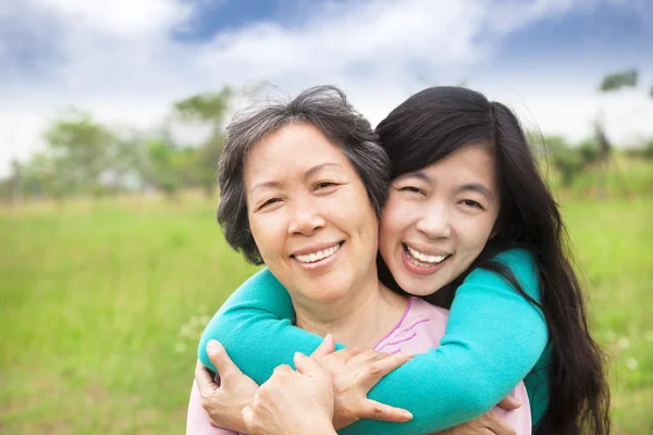 Mujer joven abrazándose con su madre — Foto de Stock