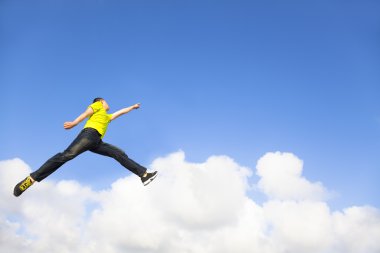 Jumping ve gökyüzü için işaret mutlu bir genç adam
