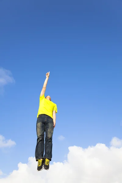 Rilassato giovane uomo che salta e punta il cielo — Foto Stock