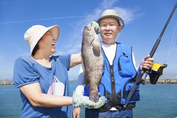 Happy asian senior couple fishing and showing big grouper — Stock Photo, Image