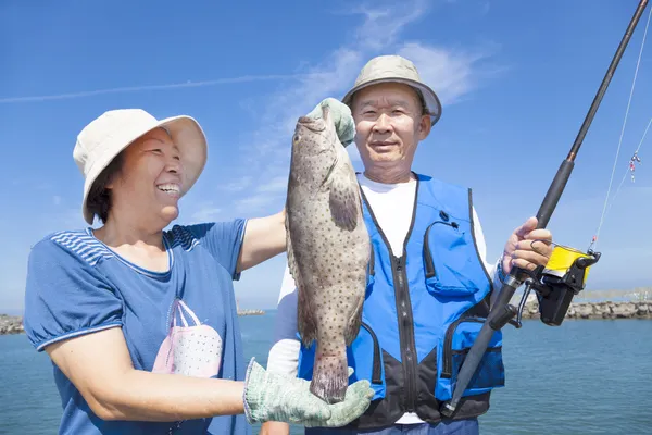 Asian senior couple fishing and showing big grouper — Stock Photo, Image