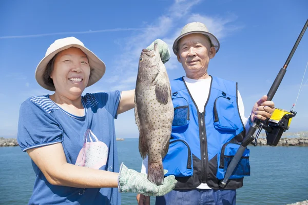 Pasangan senior yang bahagia memancing dan menunjukkan grupnya — Stok Foto