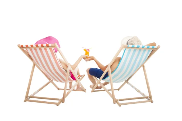 Щаслива пара сидить на пляжних стільцях і тримає апельсиновий сік — стокове фото