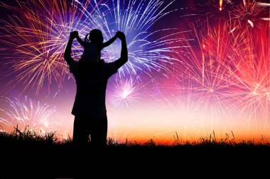 father with child standing on the hill and watching the firework clipart