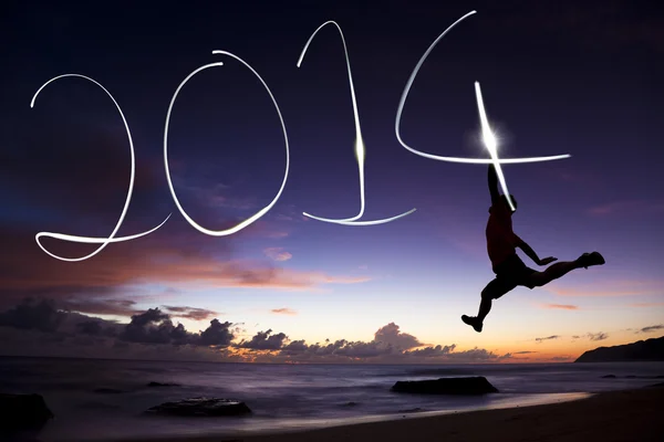 Happy new year 2014.young man jumping and drawing 2014 by flashl — Stock Photo, Image