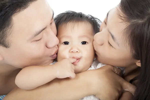 Familia feliz besando al bebé — Foto de Stock