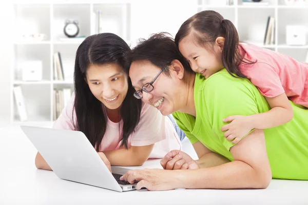 Happy family with child looking at laptop — Stock Photo, Image