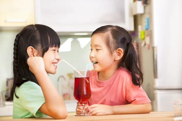 Dos niñas bebiendo jugo en casa —  Fotos de Stock