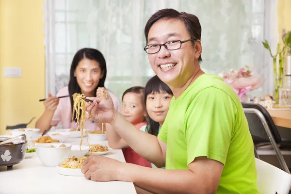 Счастливая семья ест лапшу дома — стоковое фото