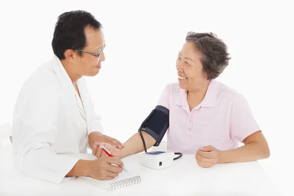 Médico que mide la presión arterial del paciente femenino — Foto de Stock