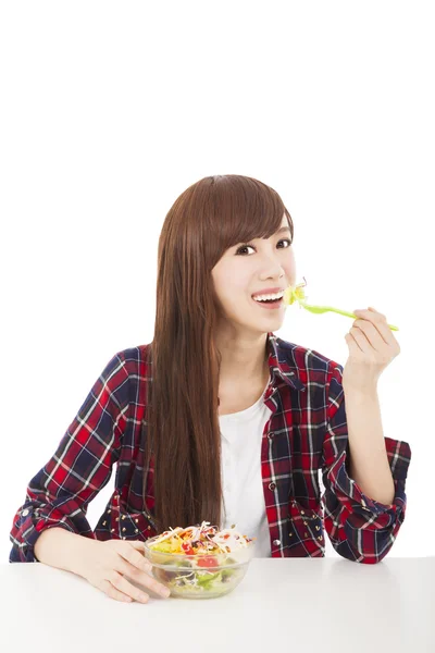 Smiling young woman eating fruits and salad — Stock Photo, Image