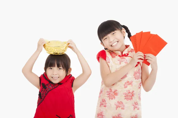 Crianças felizes mostrando envelope vermelho e ouro para o ano novo chinês — Fotografia de Stock