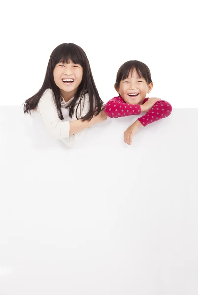 Niñas felices mostrando tablero en blanco sobre un fondo blanco —  Fotos de Stock