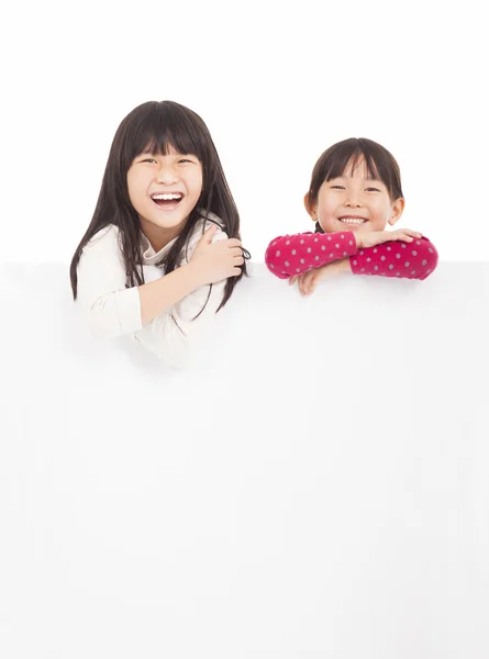 De gelukkige kinderen tonen leeg bord op een witte achtergrond — Stockfoto