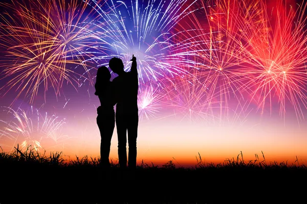 Joven pareja de pie en la colina y viendo los fuegos artificiales —  Fotos de Stock