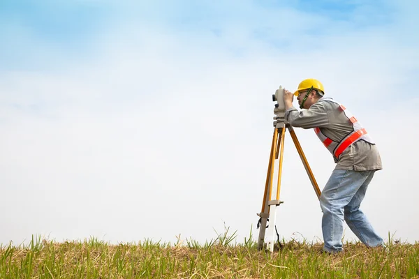 Ingeniero topógrafo toma de medidas en el campo — Foto de Stock