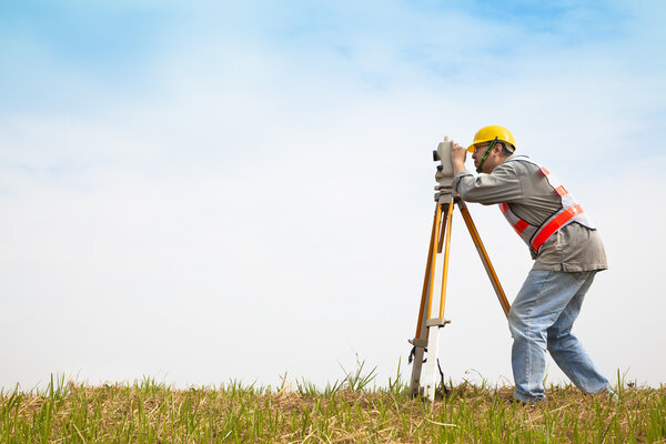 Surveyor engineer making measure on the field