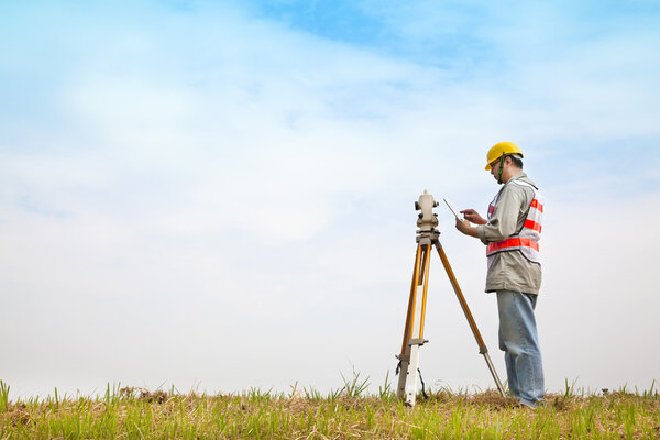 Surveyor engineer making measure on the field with tablet pc