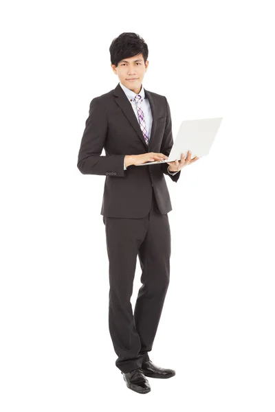 Young businessman standing with laptop — Stock Photo, Image