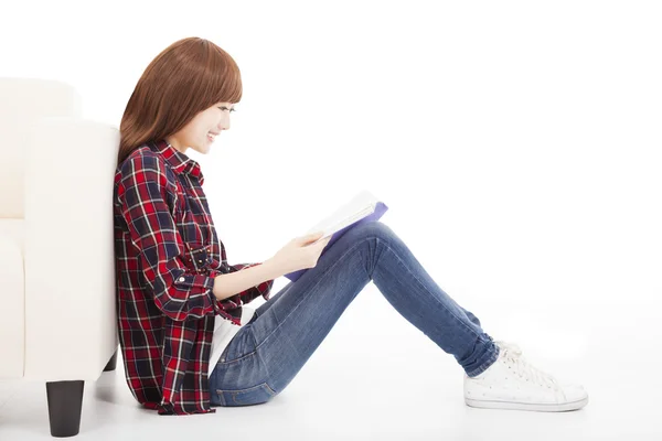 Jovem mulher lendo um livro e sentado no chão — Fotografia de Stock